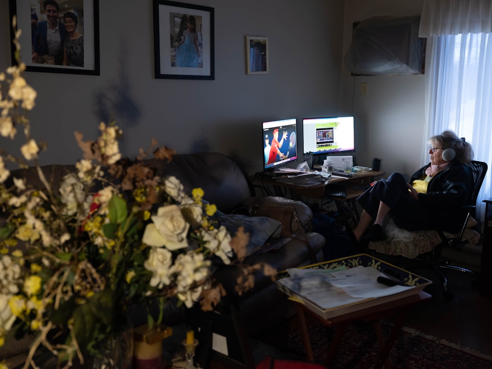 black flat screen tv turned on near white flower bouquet