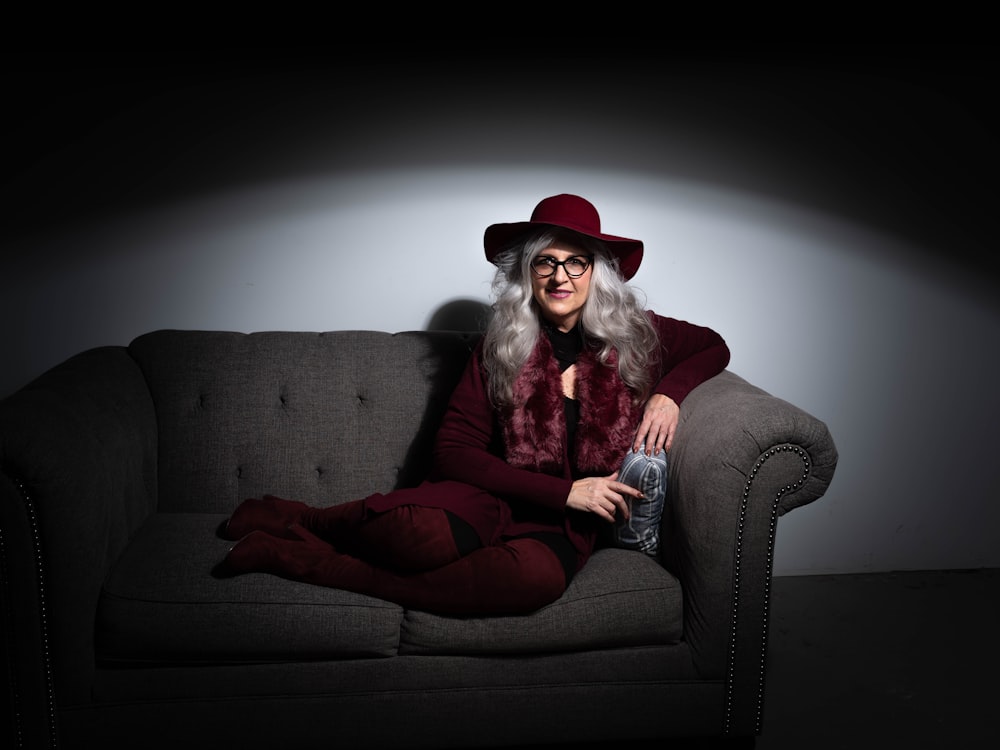 woman in red long sleeve shirt and red pants sitting on brown sofa