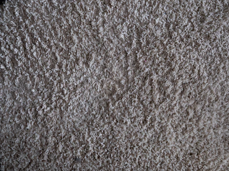 Close-up of a brown pet carpet texture showing its soft, plush fibers perfect for pets.