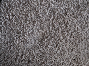Close-up of a hand gently brushing a soft carpet.