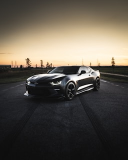 black coupe on road during sunset