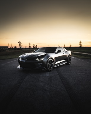 black coupe on road during sunset