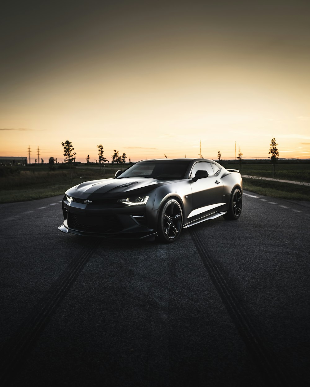 black coupe on road during sunset