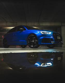 Side profile of a deep navy sports car with freshly applied ceramic coating reflecting city lights