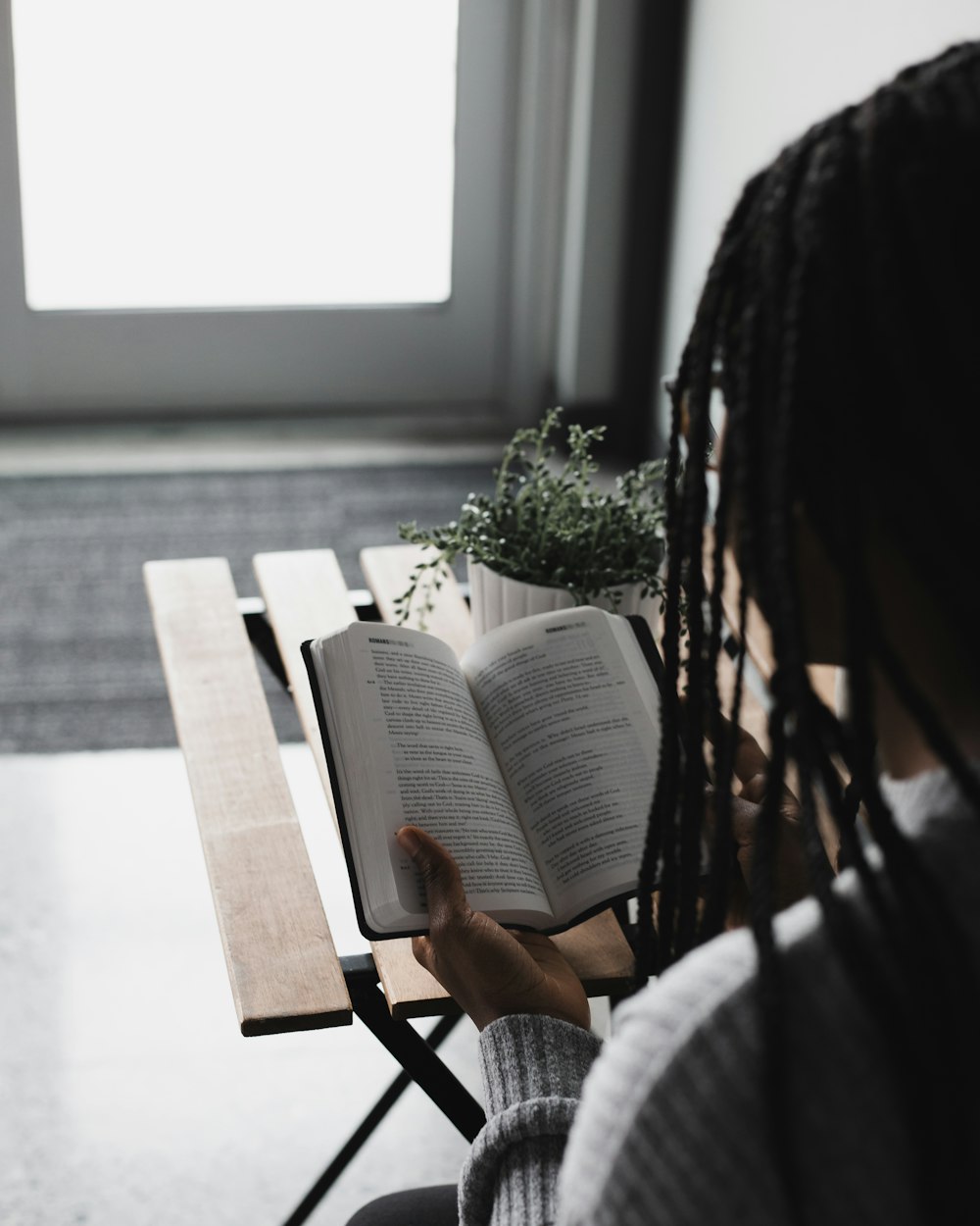 person reading book on table