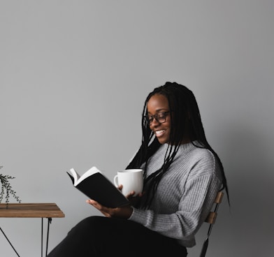 woman in white and black stripe long sleeve shirt sitting on chair