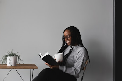 woman in white and black stripe long sleeve shirt sitting on chair