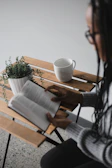 A quiet corner with a small plant and a book on a wooden table.
