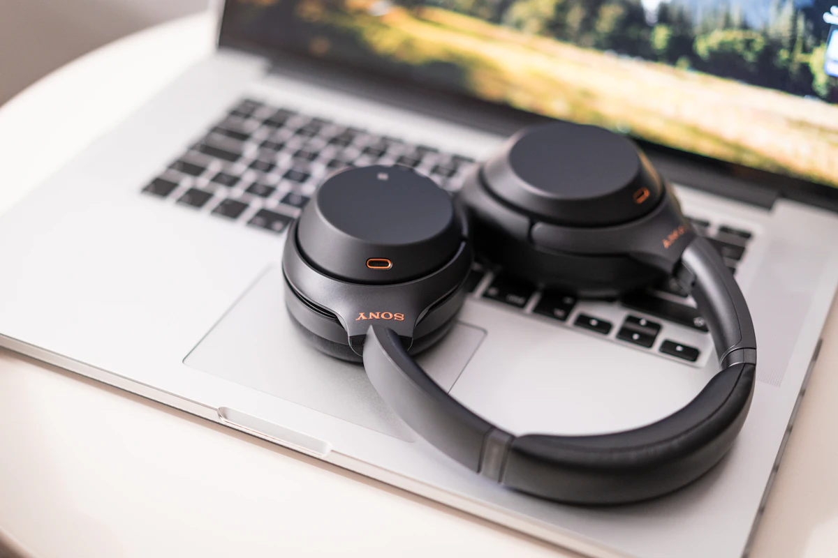 Sony WH-1000XM7 headphones resting on a laptop keyboard demonstrating multipoint Bluetooth pairing