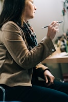 woman in brown coat holding smartphone