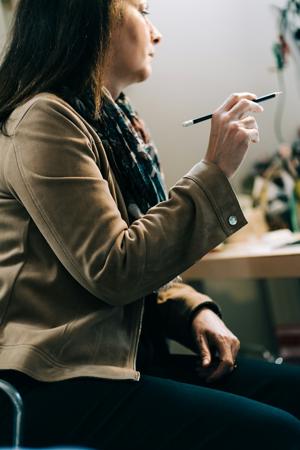 woman in brown coat holding smartphone