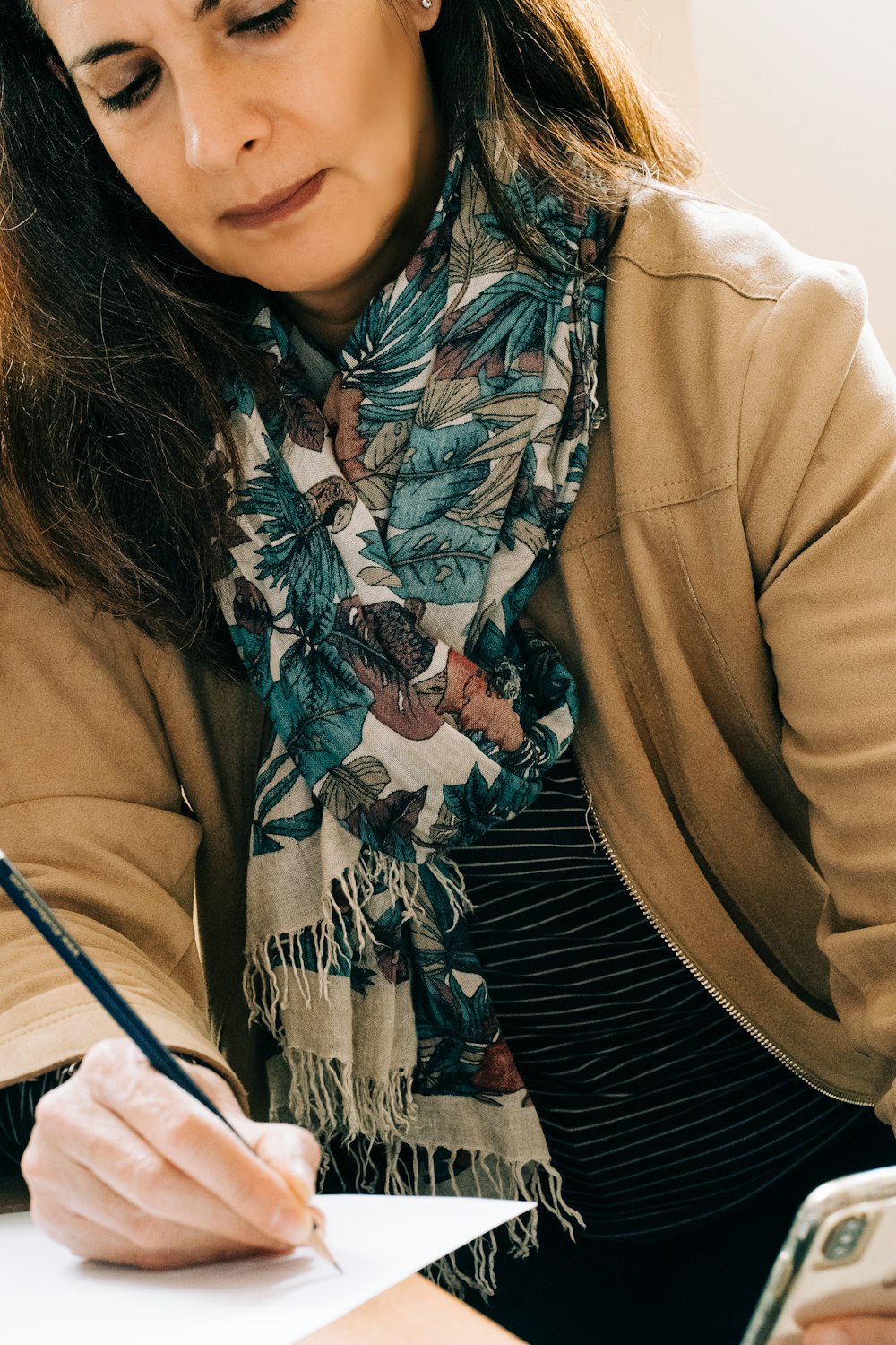 woman in brown coat with black white and red scarf