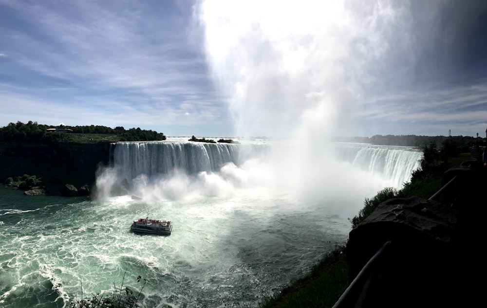 people sitting on green grass near waterfalls during daytime