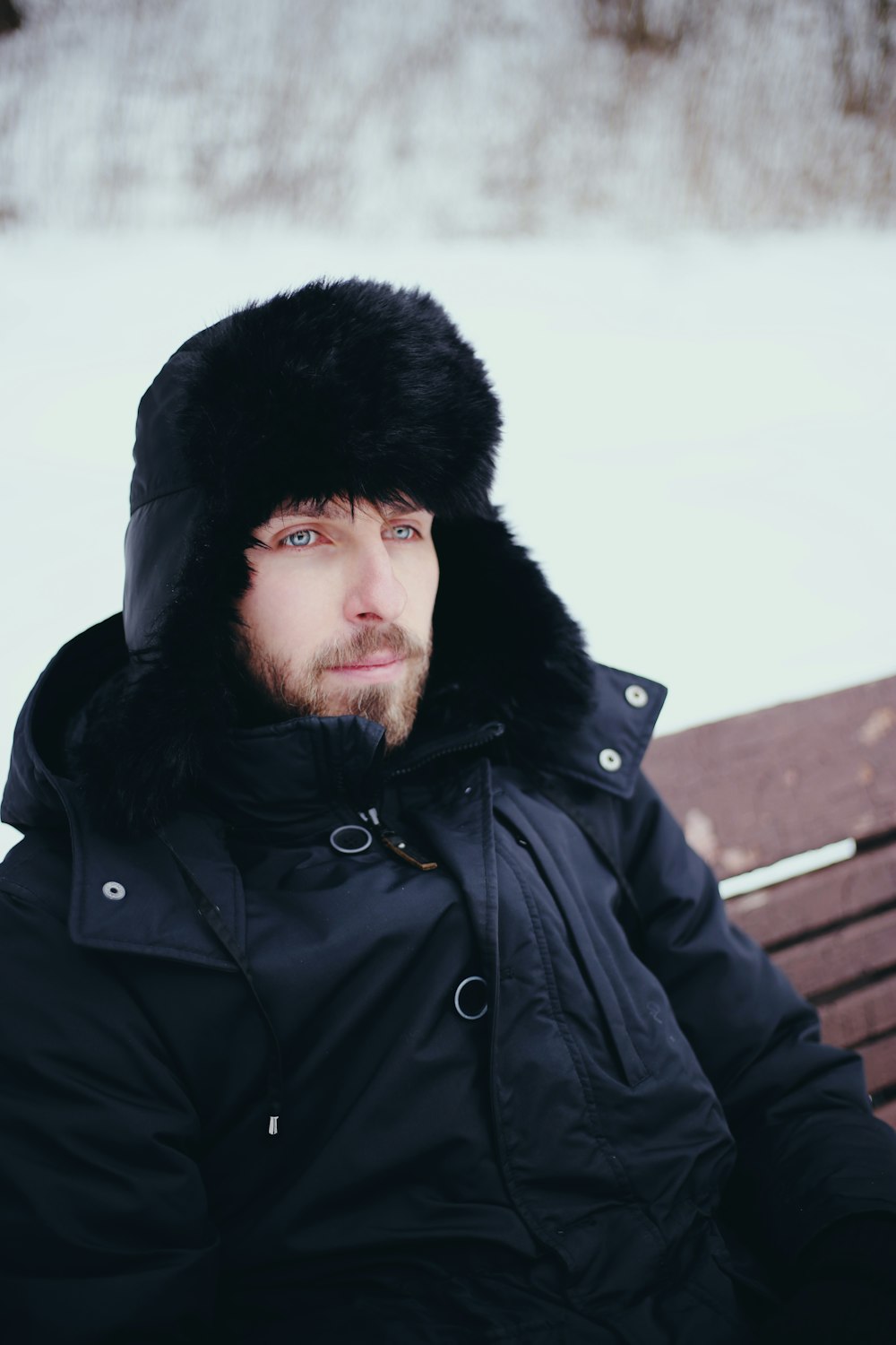 man in black jacket standing on snow covered ground during daytime