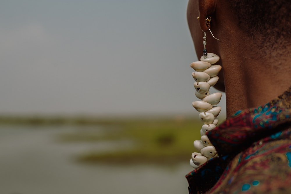 person holding white beaded necklace