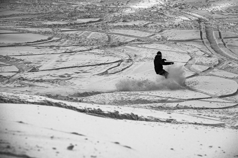 person riding on snowboard on snow covered ground during daytime