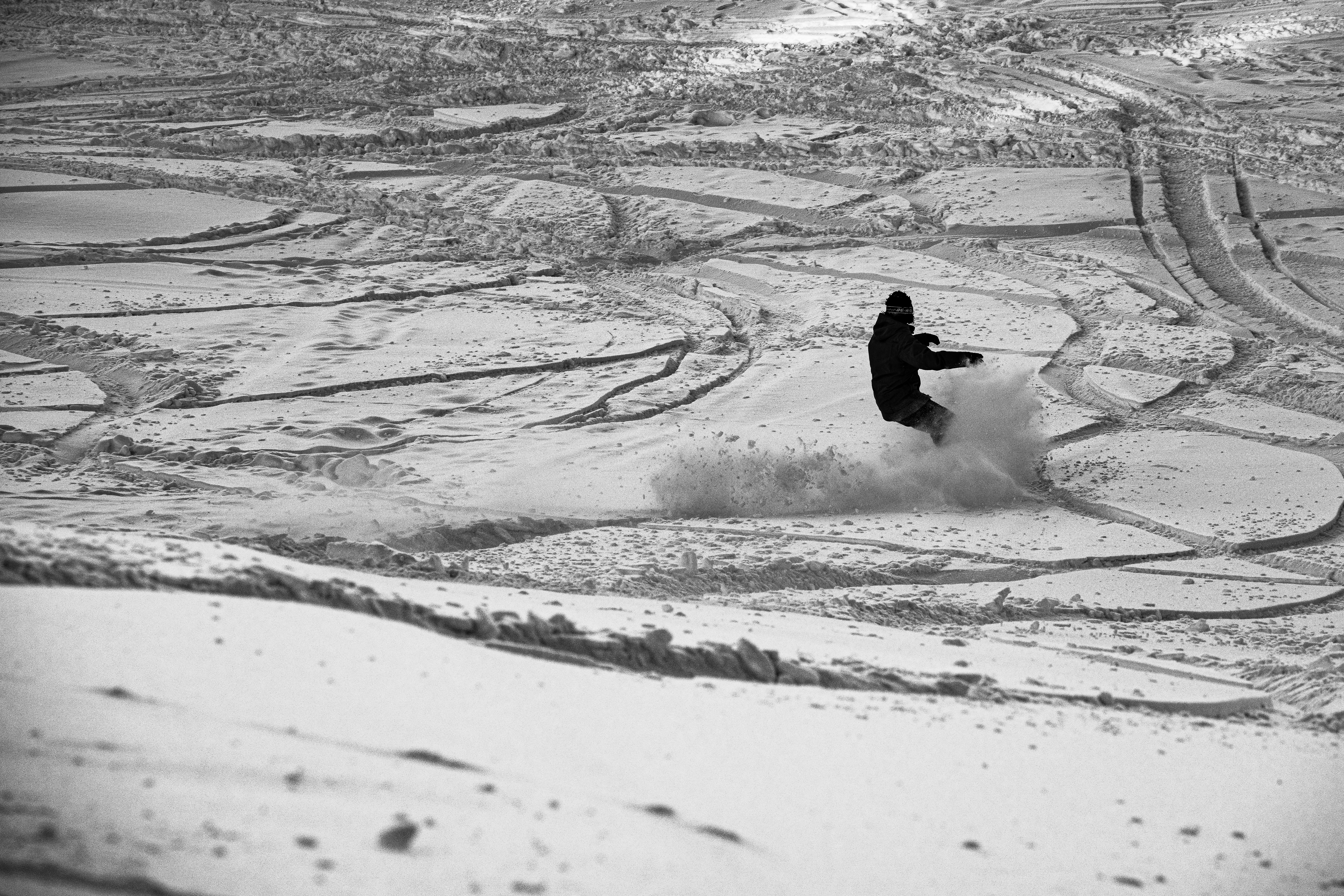 person riding on snowboard on snow covered ground during daytime