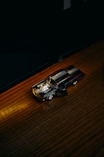 A passionate collector carefully examining a detailed classic model car under warm lighting.