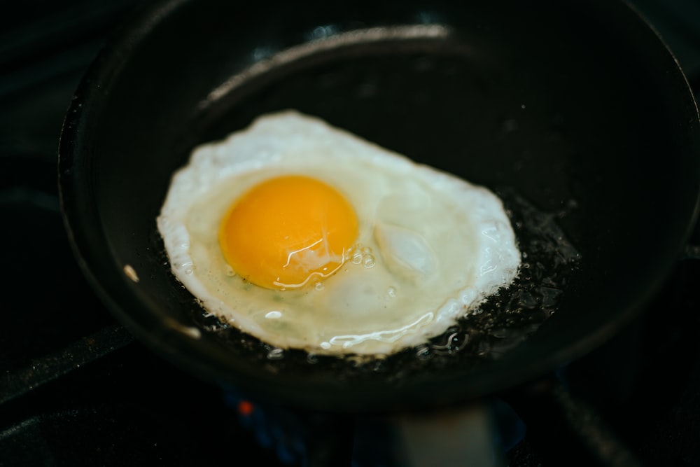 Uovo con lato soleggiato su padella nera