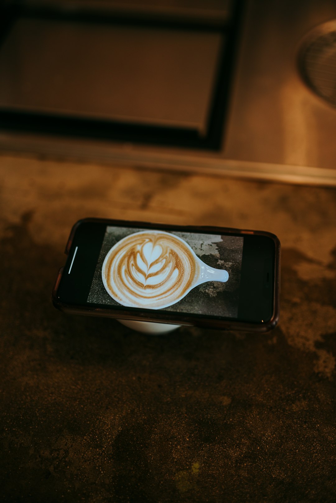 white and brown heart shaped coffee art on black ceramic saucer