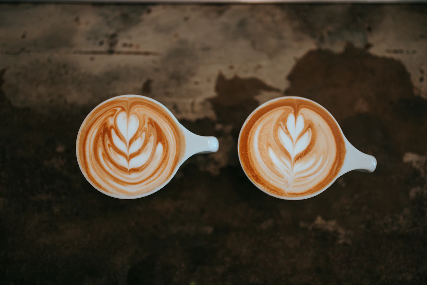 Two cups of coffee with latte art on a table