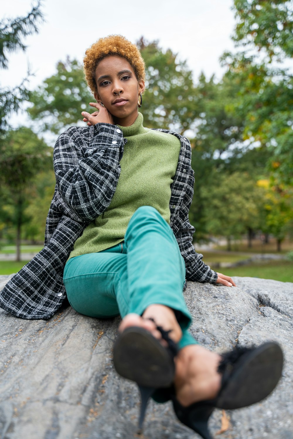 boy in green and white plaid dress shirt and green pants sitting on concrete floor during