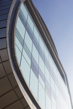 Modern building facade with clean lines and glass panels reflecting the sky.