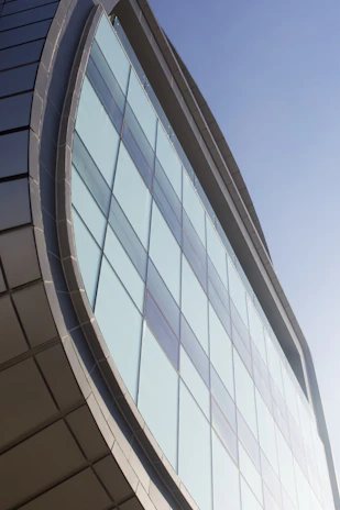 Close-up of a sleek window facade reflecting a serene sky, emphasizing minimalist design and quality materials.