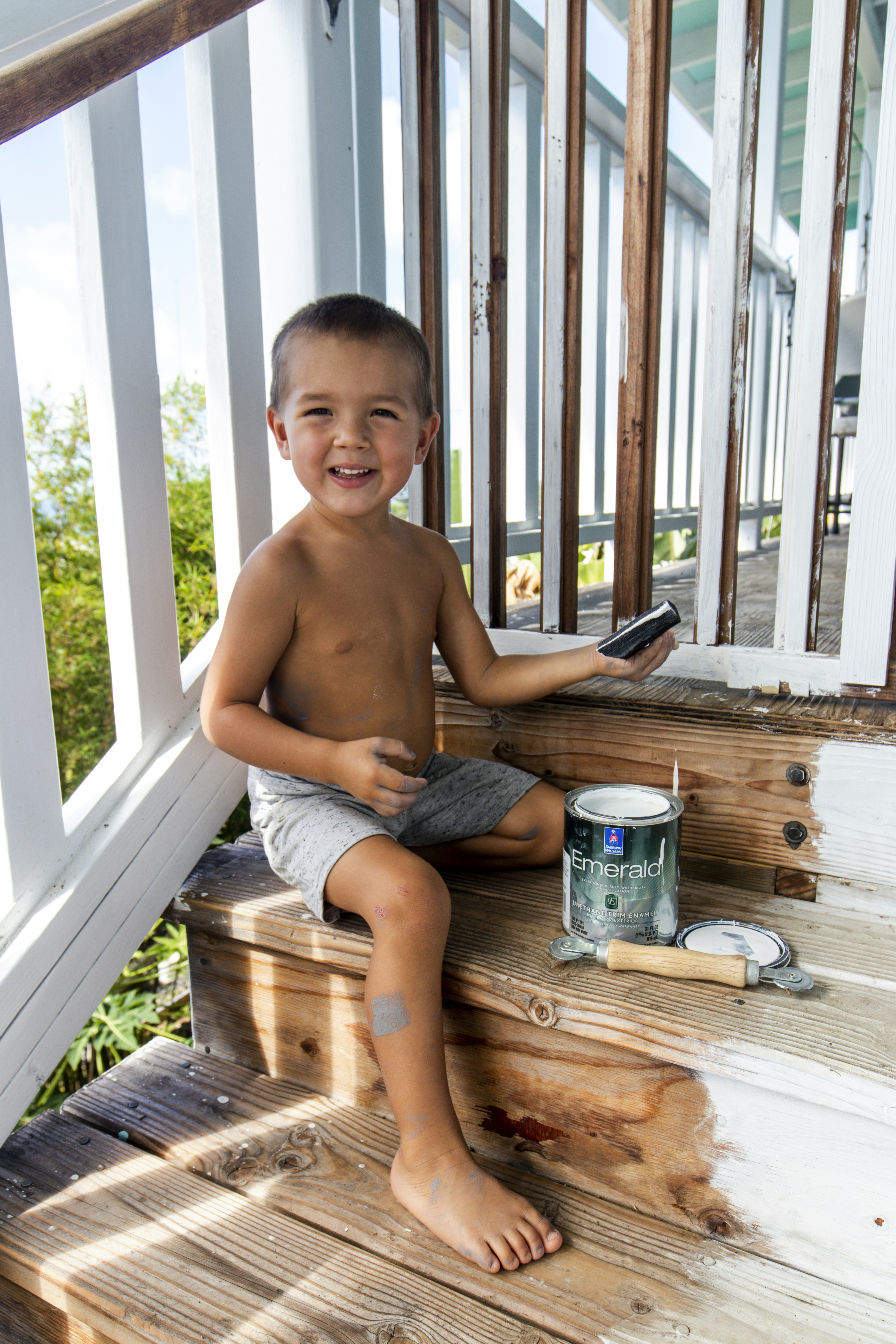 topless boy sitting on brown wooden bench