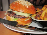 Juicy burger with melted cheese and crispy fries on the side.
