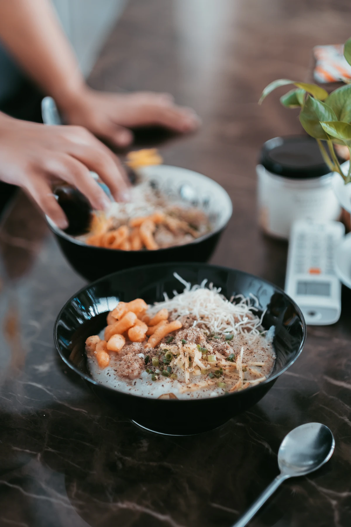 Person holding black ceramic bowl with cooked rice