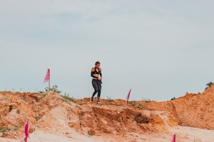 A person walking on a trail wearing breathable athletic apparel.