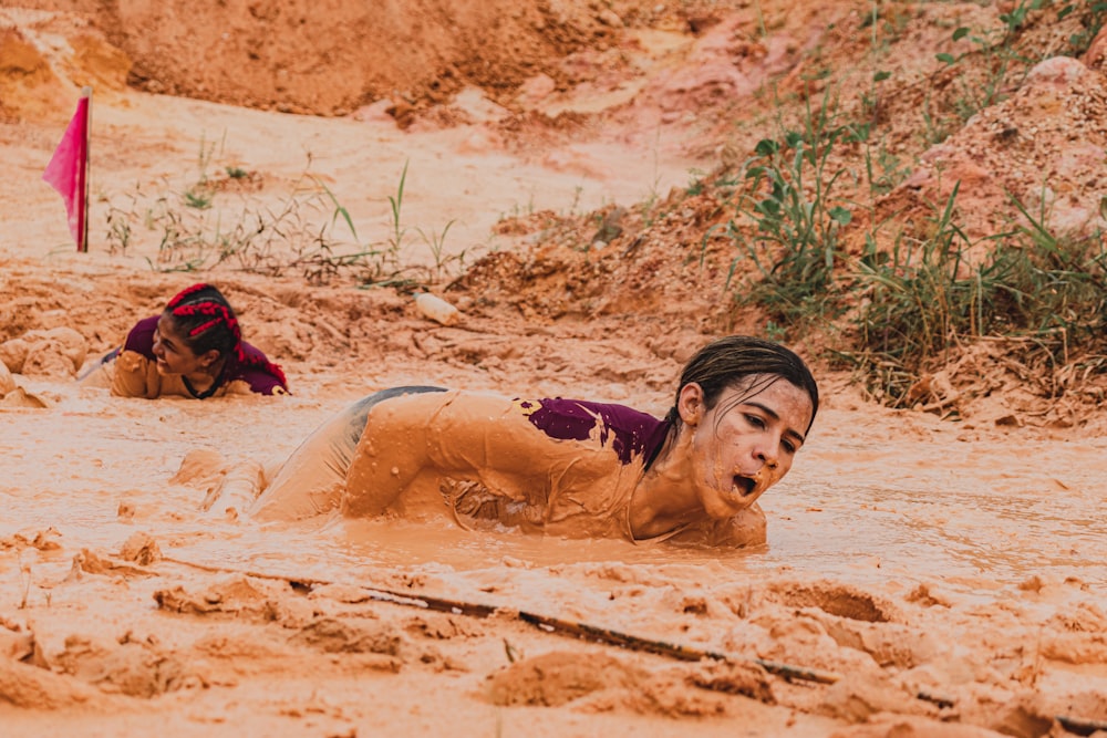 woman lying on sand during daytime