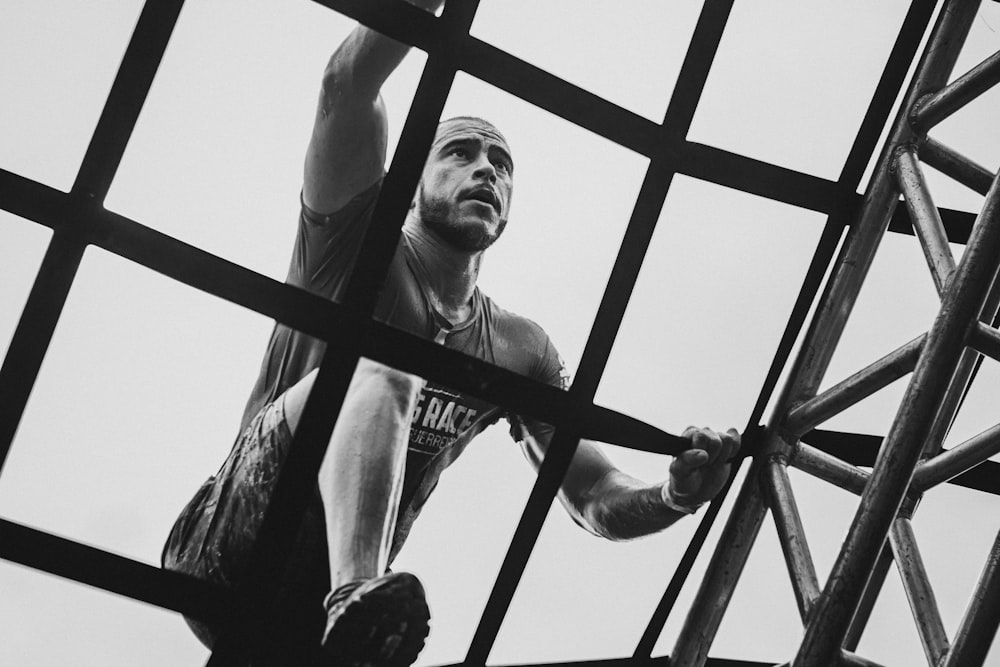 man in tank top and pants in grayscale photography