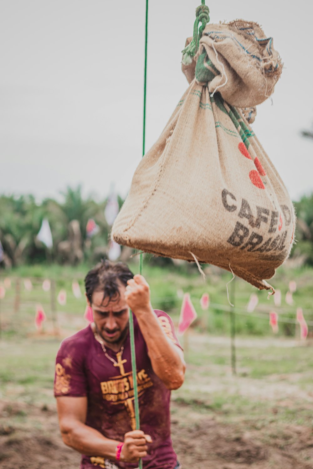 man in red shirt carrying brown paper bag