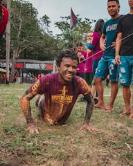 Runners climbing over a muddy obstacle during a 6 km race.