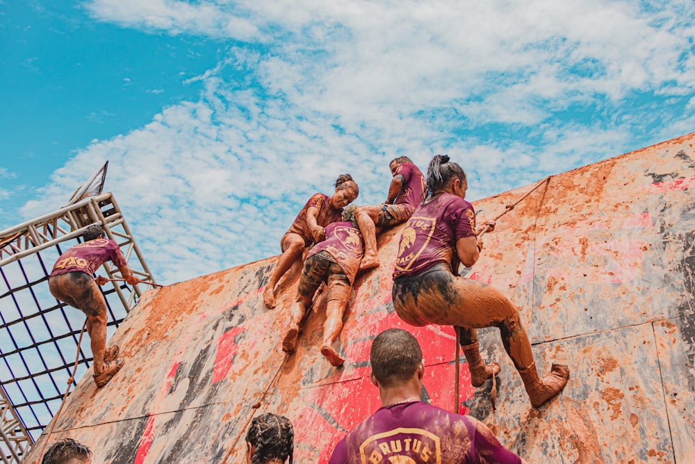 group of people climbing on brown rock formation during daytime