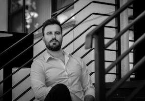 man in white dress shirt sitting on stairs