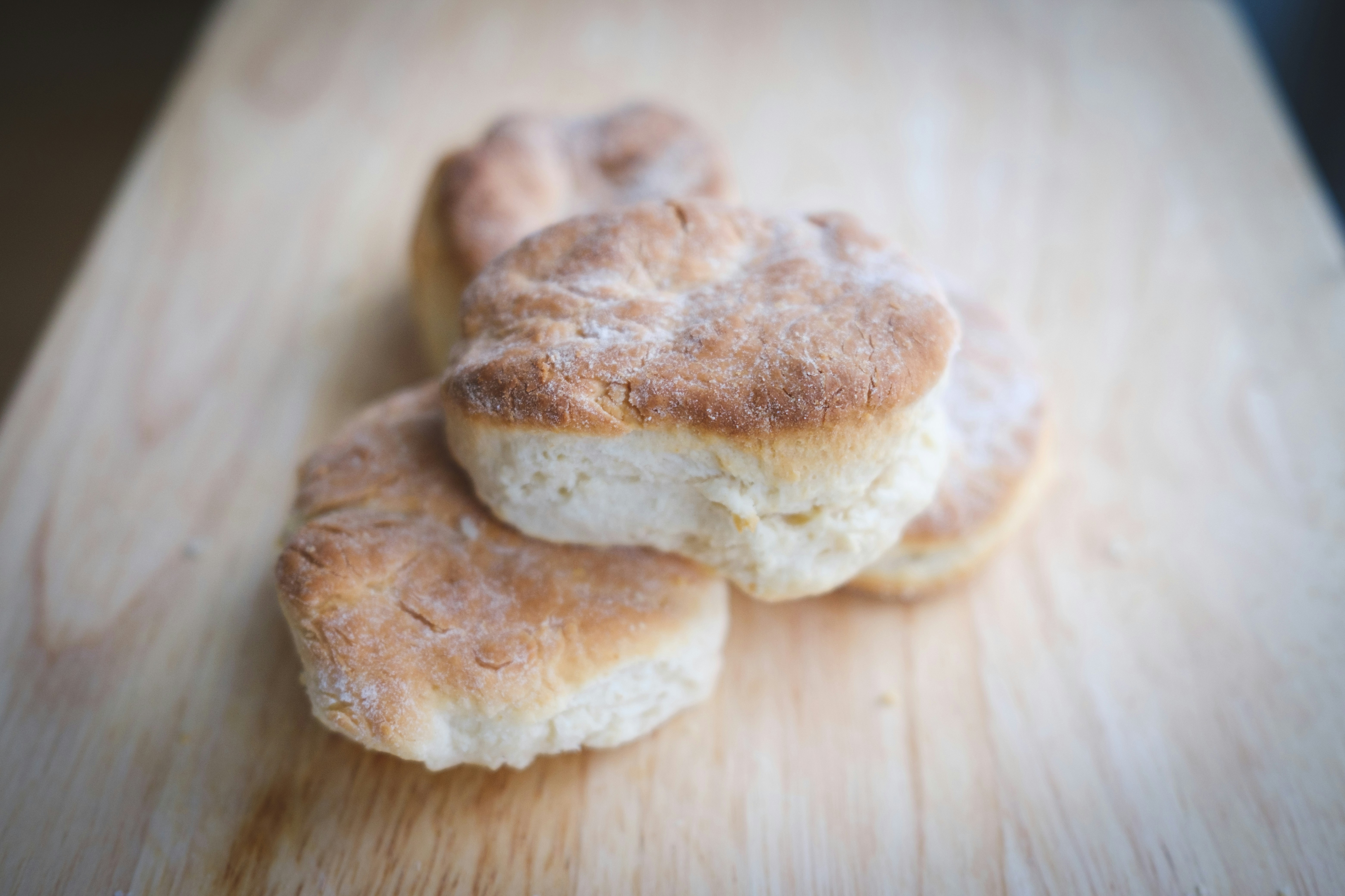 Stack of golden flaky buttermilk biscuits on a wire rack with flour dusted surface