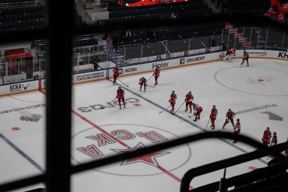 people playing ice hockey on ice field during daytime