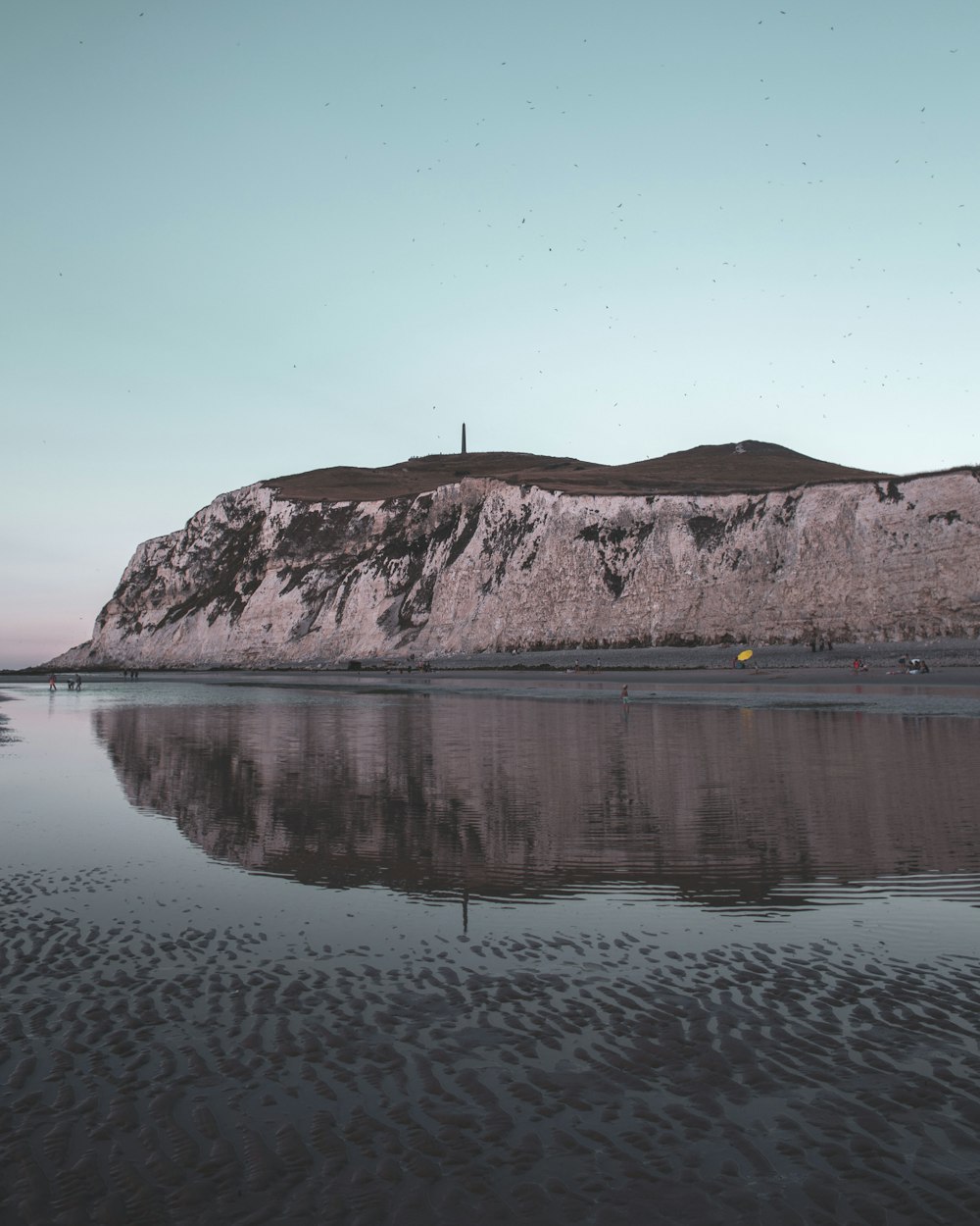 body of water near mountain during daytime