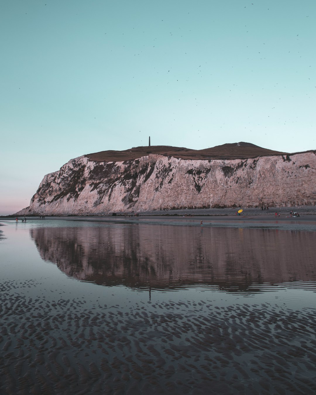 body of water near mountain during daytime