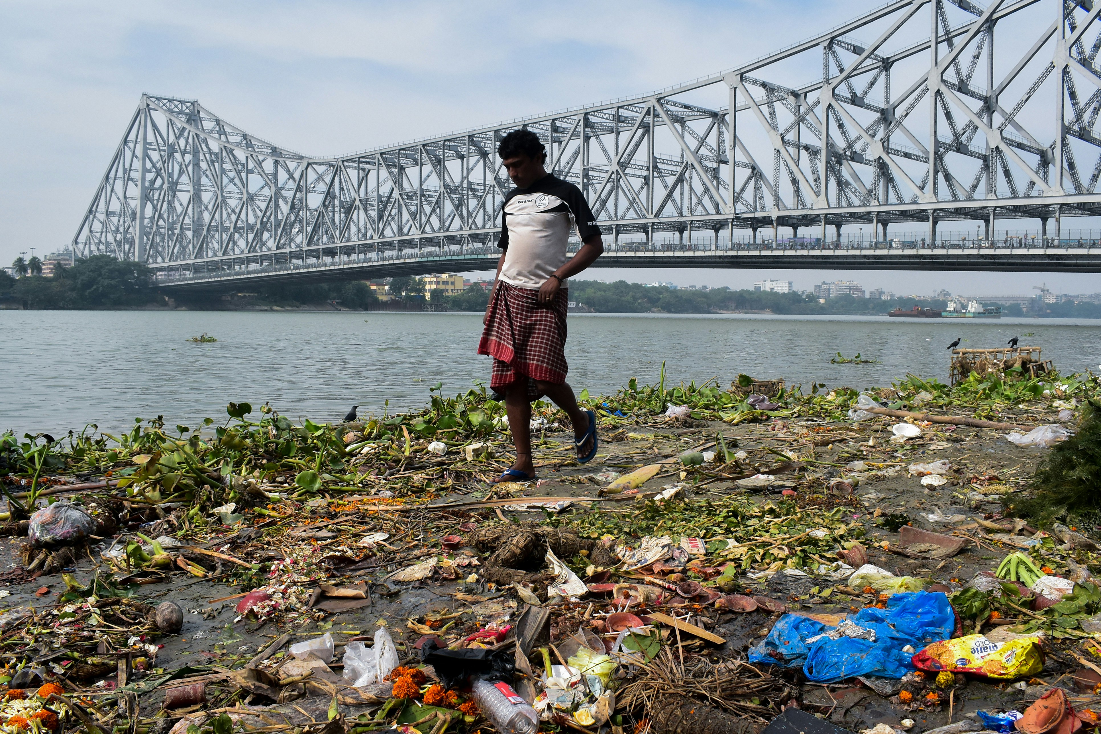 woman in white shirt and red skirt standing on brown dried leaves near bridge during daytime