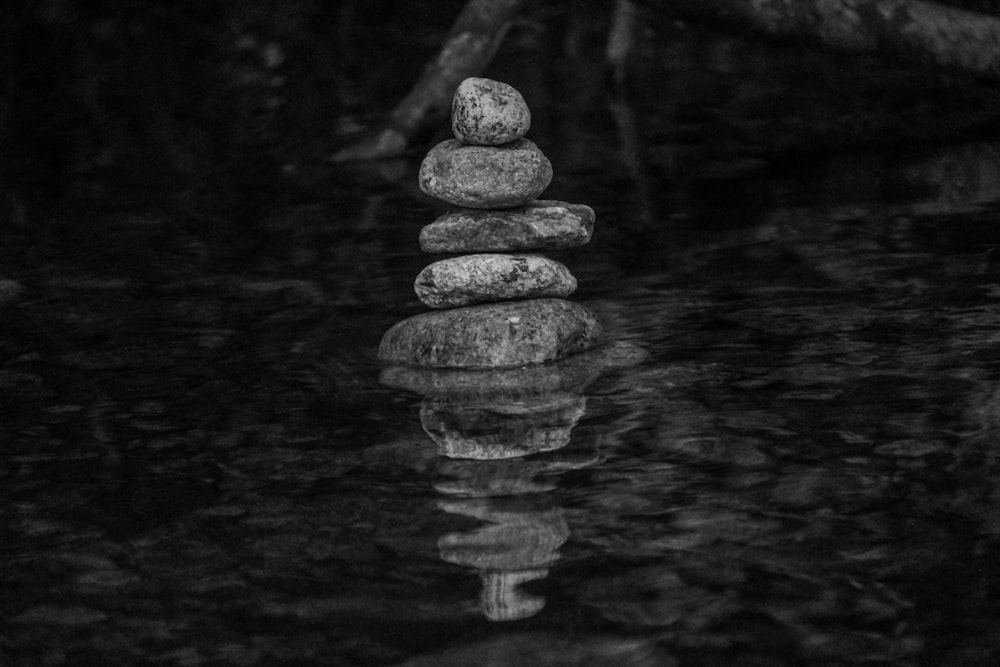 grayscale photo of stack of stones on water