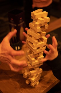Close-up of hands building a block tower, symbolizing developmental milestones.