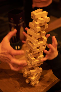Close-up of hands stacking blocks symbolizing teamwork.