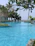 A serene backyard pool with crystal-clear water reflecting the blue sky.