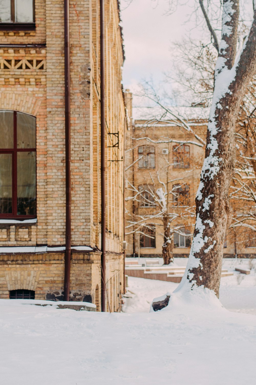 brown concrete building with snow covered ground