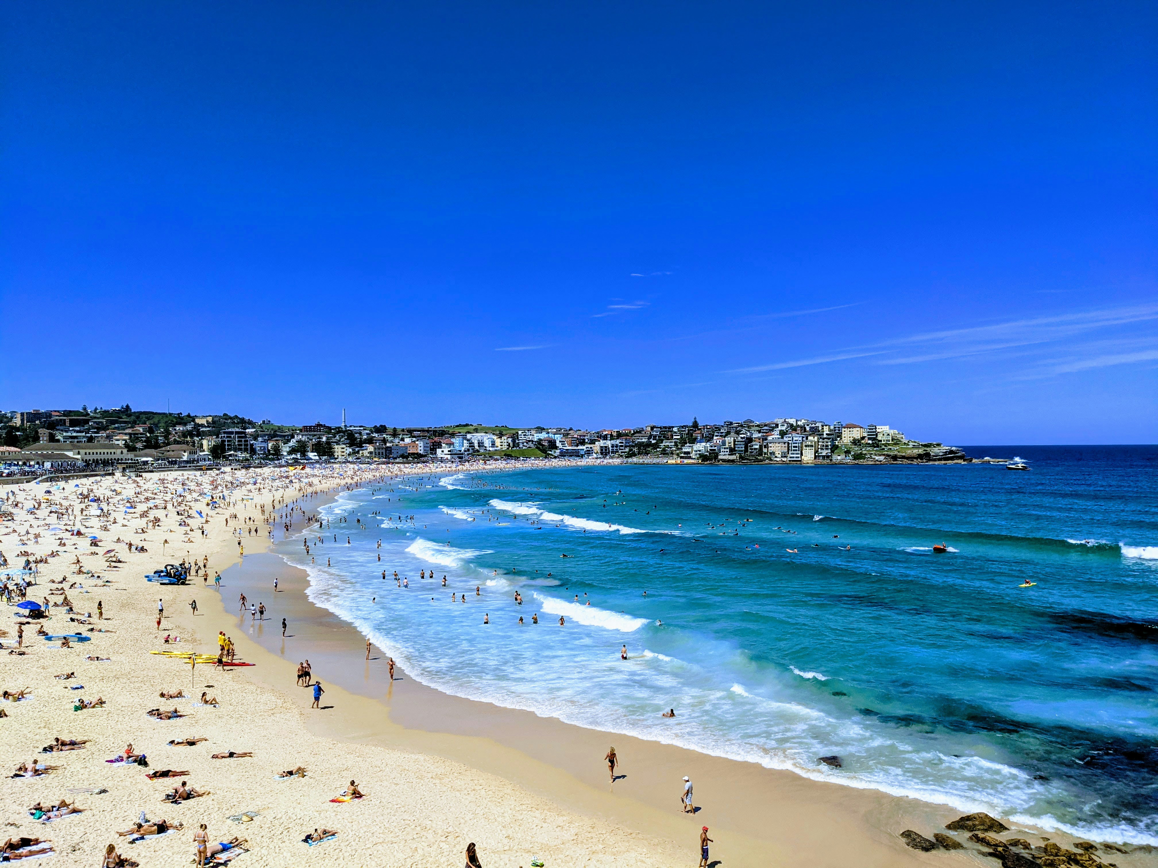 Golden sands and turquoise waves of Goa’s beach with people enjoying a lively evening.