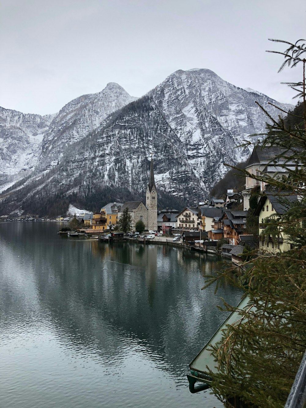 houses near lake and mountain during daytime